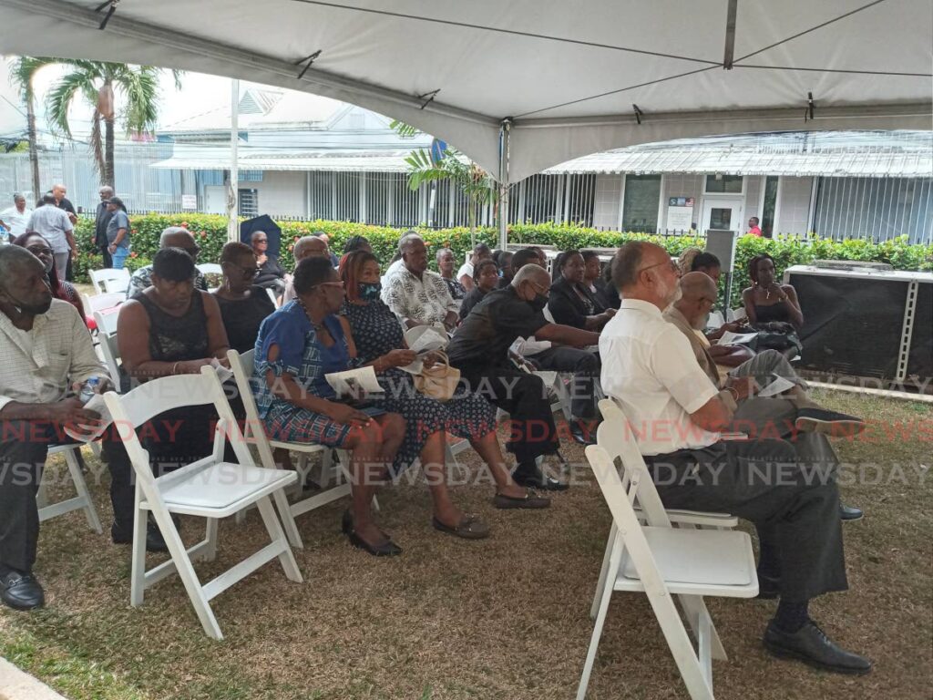 Mourners view the funeral of Verna Edwards on a screen outside All Saints Anglican Church, Queen’s Park West, on Friday. - Jelani Beckles (Image obtained at newsday.co.tt)