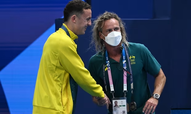 Australia’s Lani Pallister withdrew from the women’s 1500m freestyle after a positive test. Her coach, Dean Boxall, wears a mask as a precaution. Photograph: Dean Lewins/AAP (Image obtained at theguardian.com)