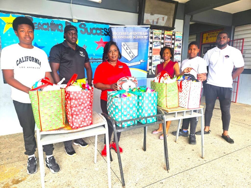 From L-R: Tariq Osborne, Success Laventille rugby coach Joseph Quashie, TT Schools' Rugby Union president Patrice Des Vignes, Success Laventille acting principal Stacey Lezama, Ky-mani Charles and TT Schools' Rugby Union vice-president Emmanuel Joseph at a hamper distribution drive at Success Laventille Secondary School on December 17. (Image obtained at newsday.co.tt)