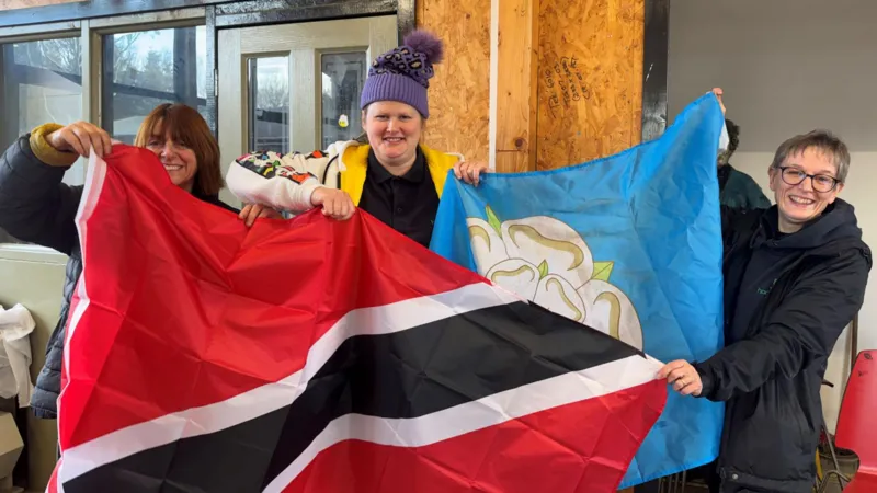 Volunteers and students waved the Trinidad and Tobago and Yorkshire flag side by side (Image obtained at bbc.com)